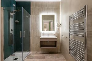 ein Badezimmer mit Waschbecken, Dusche und Spiegel in der Unterkunft Petit Hotel in Prato