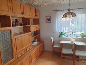 une cuisine avec des placards en bois, une table et une fenêtre dans l'établissement Ferienhaus Keppler im Erzgebirge, à Sayda