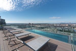 a group of tables and chairs on the roof of a building at Hoch hinaus, neu und stilvoll mit Pool am Dach in Vienna