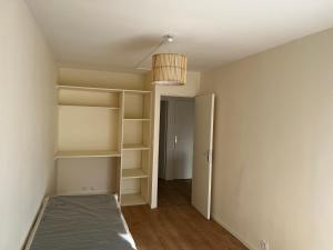 an empty room with a bed and a light fixture at Chambre privée dans appartement en colocation 4 chambres Longjumeau proche Orly, Massy in Longjumeau