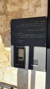 a sign in a stone wall with a television at City Port Hotel in Haifa