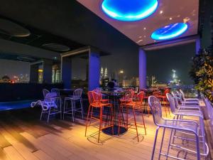 - un bar avec des chaises et des tables sur une terrasse la nuit dans l'établissement Deluxe Suites D'Majestic Place, KL City Centre, à Kuala Lumpur