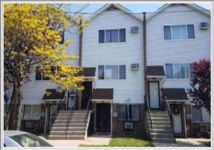 a large white house with stairs in front of it at Oasis Stay NY, 2BR Cozy Home in a 2Family House, 18min from the City in Unionport