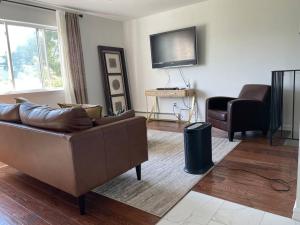 a living room with a couch and a television at Oasis Stay NY, 2BR Cozy Home in a 2Family House, 18min from the City in Unionport