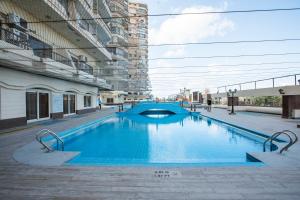 a large blue swimming pool in a city street at AIFU Hotel El Montazah Alexandria in Alexandria