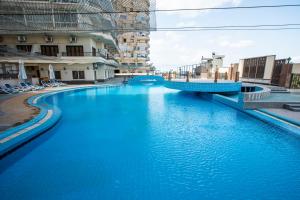 duży basen z błękitną wodą obok niektórych budynków w obiekcie AIFU Hotel El Montazah Alexandria w Aleksandrii