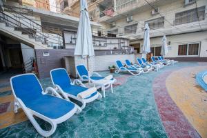 un grupo de sillas y sombrillas en una piscina en AIFU Hotel El Montazah Alexandria, en Alejandría