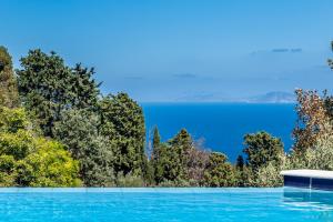 a swimming pool with a view of the water at Villa Pasifika in Loutraki