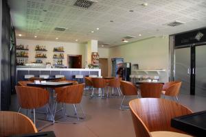 a restaurant with chairs and tables and a bar at Hotel Europa in Utebo