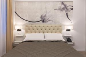 a bedroom with a bed with two night stands and two lamps at Petit Hotel in Prato