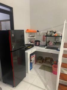 Awana Dream Gateway Pasteur في باندونغ: مطبخ مع ثلاجة سوداء في الغرفة
