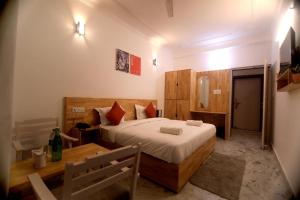 a bedroom with a bed and a table in a room at Chakrah by Hermitage Rishikesh in Rishīkesh