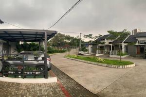 une voiture garée dans un parking à côté d'une maison dans l'établissement Awana Dream Gateway Pasteur, à Bandung