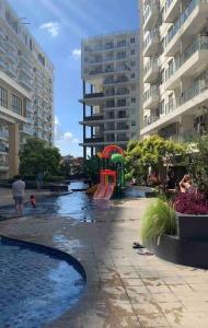 a pool in a city with a playground and buildings at Awana Dream Gateway Pasteur in Bandung