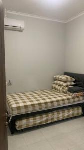 Una cama en una habitación con algunas almohadas. en Awana Dream Gateway Pasteur, en Bandung