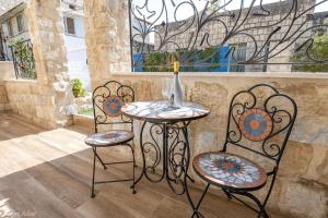 un tavolo e due sedie seduti accanto a una finestra di Heart Mansion Rashbi compound a Safed