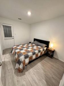 a bedroom with a bed and a table and a window at Lackland-area new cozy 2BR home in San Antonio