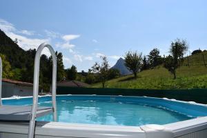 a swimming pool with a chair next to a hill at LA CASA AZUL, un oasis de calma, vistas impresionantes con PISCINA, SALTADOR, BARBACOA y acceso al río Asón in Ramales de la Victoria