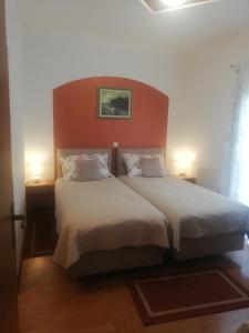 a bedroom with a large bed with two lamps at Guest House Surina in Rupa