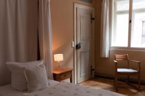 ein Schlafzimmer mit einem Bett, einem Stuhl und einem Fenster in der Unterkunft Hotel am Hoken in Quedlinburg