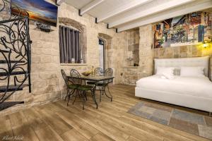 1 dormitorio con 1 cama, mesa y sillas en Heart Mansion Rashbi compound en Safed