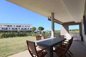 - une table et des chaises noires sur la terrasse dans l'établissement Apartamento Familiar La Reserva, à El Rompido