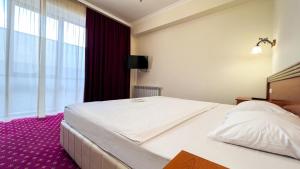 Voodi või voodid majutusasutuse Olympavan Hotel toas