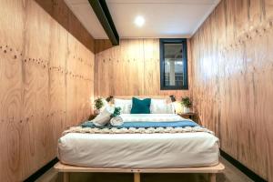 a large bed in a room with wooden walls at Joshi’s - Dog & kid friendly guesthouse in Agnes Water