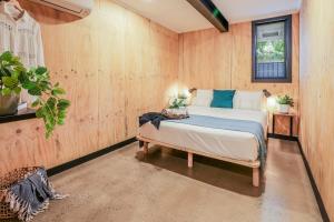 a bedroom with a bed in a room with wooden walls at Joshi’s - Dog & kid friendly guesthouse in Agnes Water