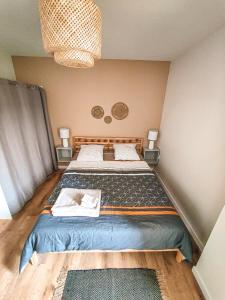 een bed in een kamer met twee tafels en twee lampen bij Nouveau T2 en face du lac - Meublé tourisme - Garage privé in Évian-les-Bains