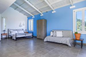 ルートラキにあるVilla Pasifikaの青い壁のベッドルーム1室、ベッド1台、ソファが備わります。