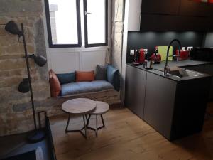 a kitchen with a couch and a table and a sink at bnbgônes - LE LOFT BODIN Croix Rousse - METRO in Lyon
