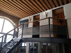 a spiral staircase in a room with a window at bnbgônes - LE LOFT BODIN Croix Rousse - METRO in Lyon