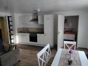 a kitchen and living room with a table and chairs at Soutterain - Wohnung mit Senkgarten in Weingarten (Karlsruhe)