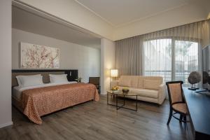 エルサレムにあるダン エルサレム ホテルのベッドルーム1室(ベッド1台、ソファ、テーブル付)