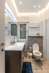 a bathroom with a white toilet and a sink at L.T.D luxury apartments 4 bedroom panoramic view in Tiberias