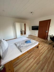 a large white bed in a room with a wooden floor at MR-Ferienwohnung - Wohnung Hönnersum in Harsum