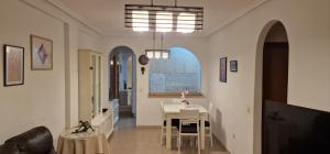 a living room with a table and a dining room at PalmeraV in Santa Pola