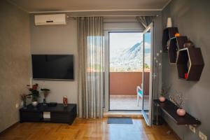 ein Wohnzimmer mit einer Tür, die auf einen Balkon führt in der Unterkunft Sea view apartment in Kotor ! Apartment Popica in Kotor