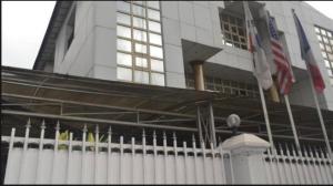 una cerca blanca frente a un edificio con banderas en Whitehouse Msquare Hotel en Ikeja