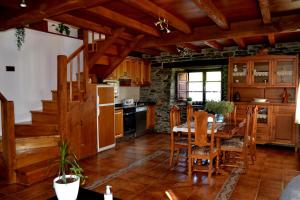 a kitchen with a table and chairs and a kitchen with wooden cabinets at Apartamentos Rurales RON in Ron