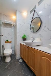 a bathroom with a sink and a toilet and a mirror at AMANI 133, 4 Minutes to Airport, FAST WI-FI, Free Netflix in Pusok