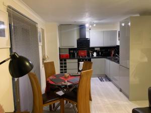 a kitchen and dining room with a table and chairs at Modern 2 bed apartment in Wallasey