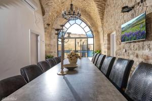 a dining room with a long table and chairs at The Antiquity Heart Mansion in Safed