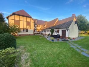 une grande maison avec une cour en face dans l'établissement La pommeraie76, à Saint-Ouen-sous-Bailly