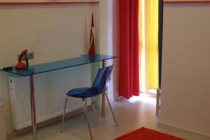 a blue chair sitting next to a desk in a room at Room in a neoclassical house - ladybug in Kastoria