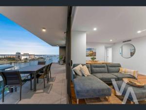 a living room with a couch and a table on a balcony at 3 Bedroom Sub Penthouse Apartment in the heart of Newcastle in Wickham