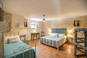 a bedroom with two beds and a table and chairs at Country House da Già in Ostuni