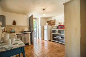 a kitchen with a refrigerator and a tile floor at Country House da Già in Ostuni