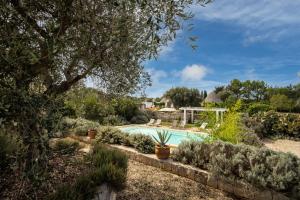 a swimming pool in a garden with plants at Country House da Già in Ostuni